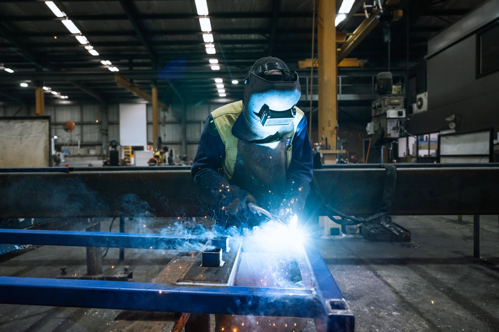 Metal fabrication process with sparks flying in an industrial workshop.